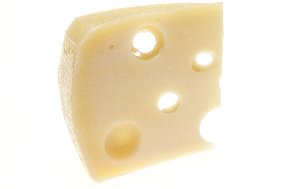 Auto-generated description: A piece of Swiss cheese with characteristic holes is shown against a white background.