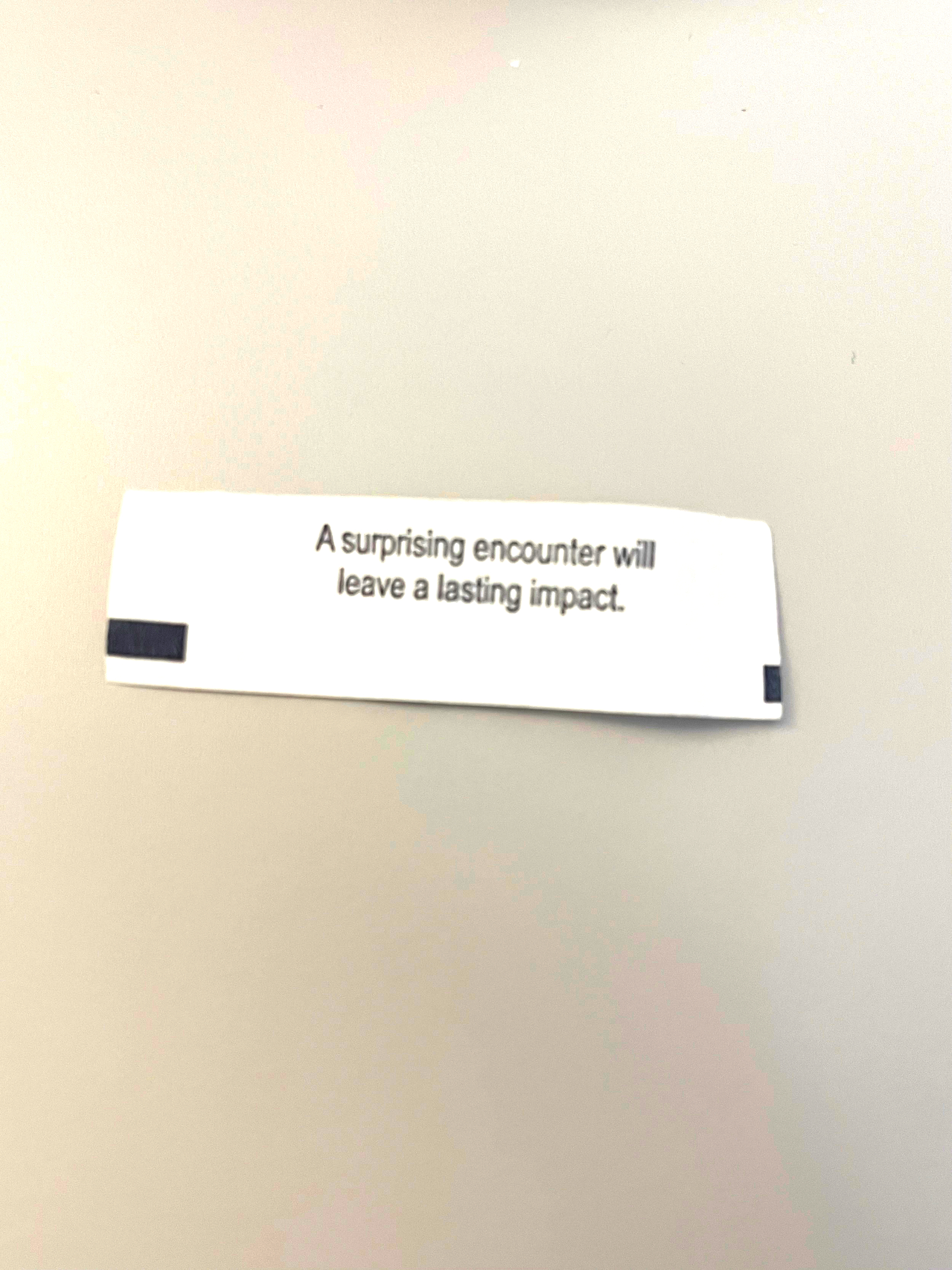 Auto-generated description: A fortune cookie slip reads, A surprising encounter will leave a lasting impact.